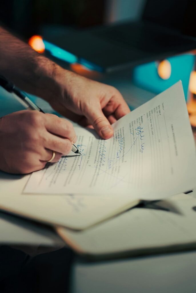 Person signing a will with a pen